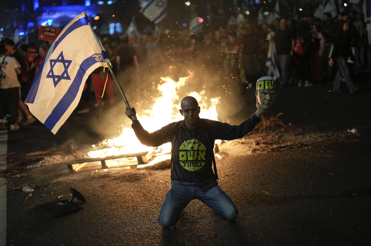 A protestor holds the Israeli flag during a protest following Prime Minister Benjamin Netanyahu’s dismissal of the Israeli Defense Minister Nov. 5. Opinion Columnist Santiago Montañez Bertoletti warns that if Israel continues to navigate conflicts with little regard for human life, it’ll be no better than the terrorist organizations it aims to defeat. (AP Photo/Francisco Seco, File)